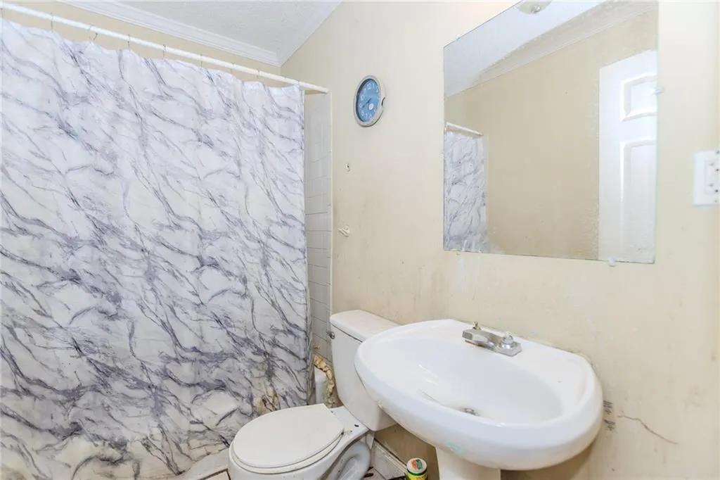 Bathroom featuring ornamental molding and a stall shower