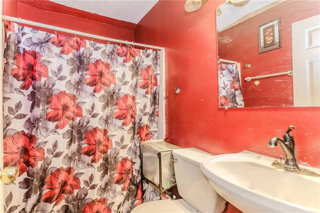 Full bath with a textured ceiling and curtained shower