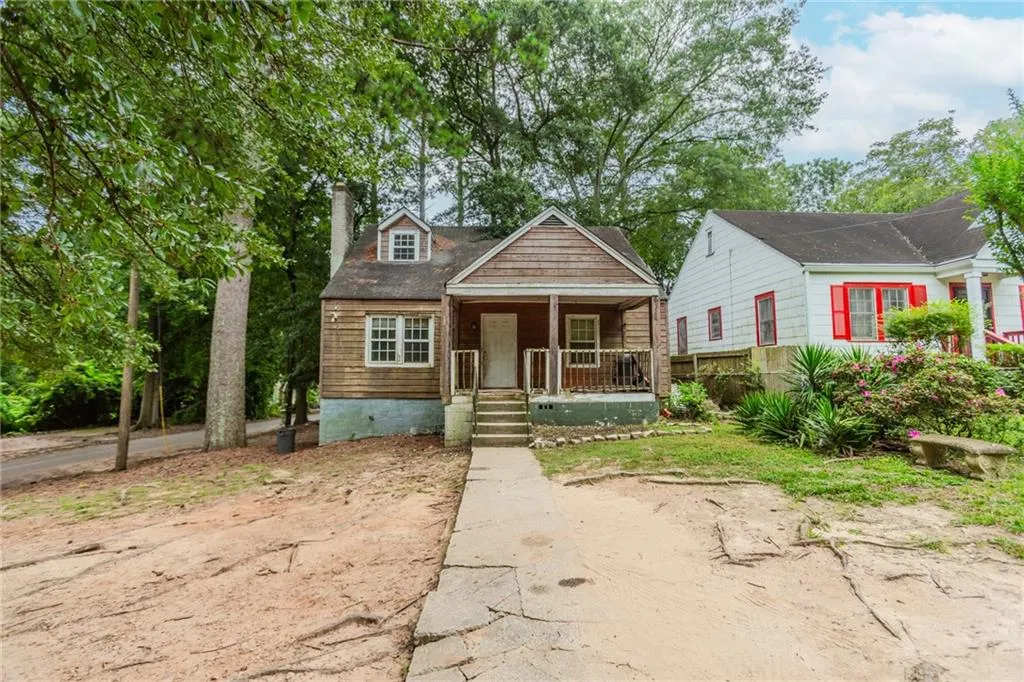 View of front of house featuring a porch and a chimney
