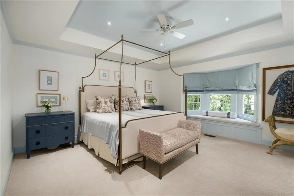 Spacious  primary bedroom has tray ceiling and charming built-in window seat.
