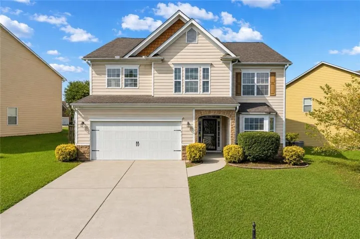 Two-story colonial featuring a white-painted brick exterior with architectural gable detailing, multi-pane double-hung windows, and a covered front entry