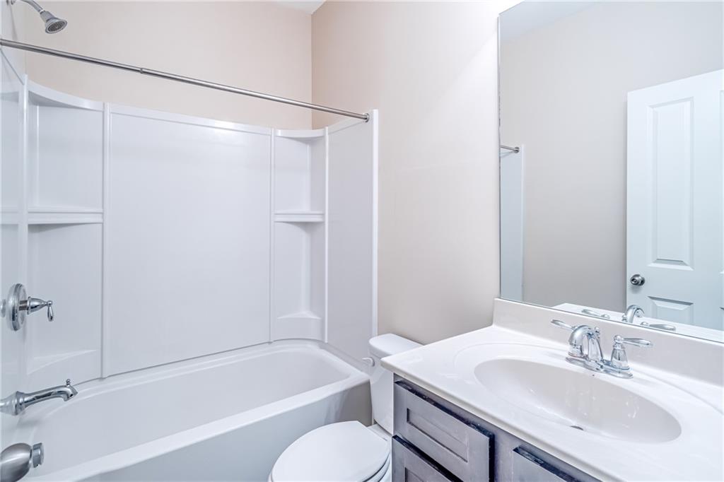 Full bathroom featuring toilet, bathing tub / shower combination, and vanity Full bathroom featuring toilet, bathing tub / shower combination, and vanity