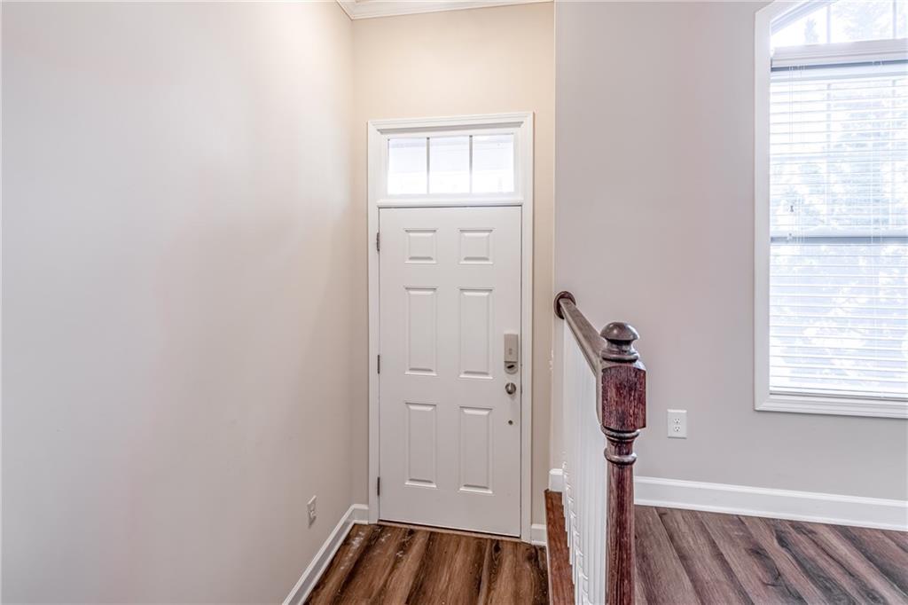 Doorway to outside featuring dark hardwood / wood-style floors Doorway to outside featuring dark hardwood / wood-style floors