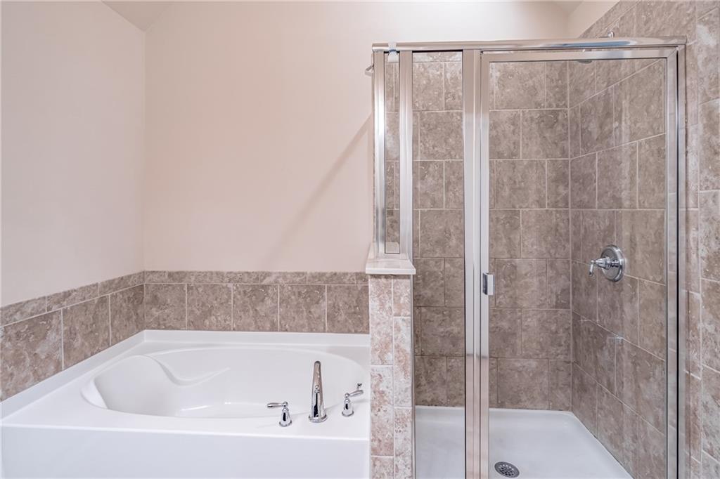 Bathroom featuring shower with separate bathtub Bathroom featuring shower with separate bathtub