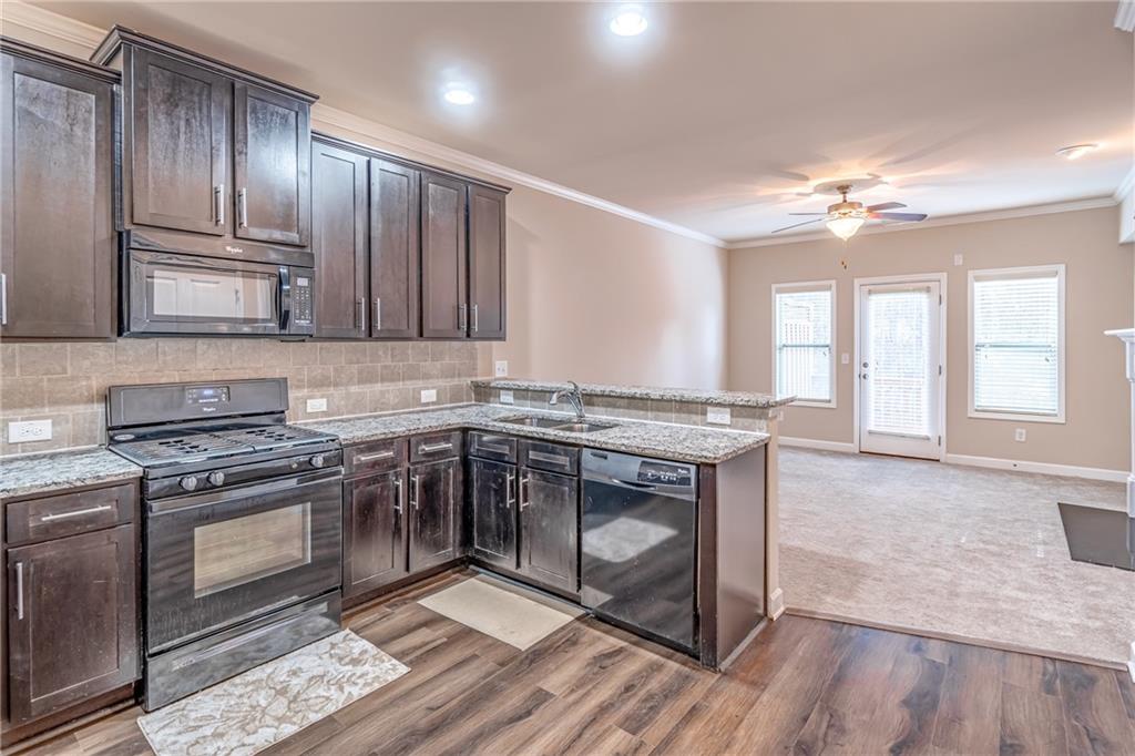 Kitchen with black appliances, ceiling fan, and light hardwood / wood-style floors Kitchen with black appliances, ceiling fan, and light hardwood / wood-style floors
