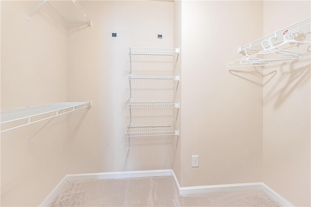 Spacious closet with light carpet Spacious closet with light carpet