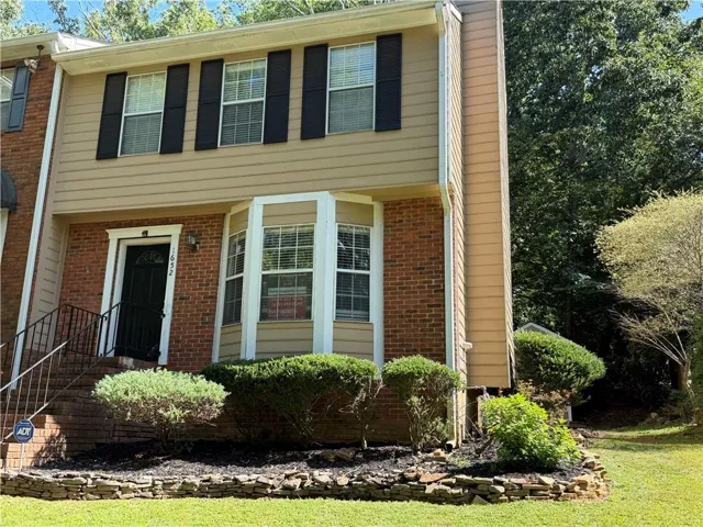 Brick and siding exterior with black window shutters