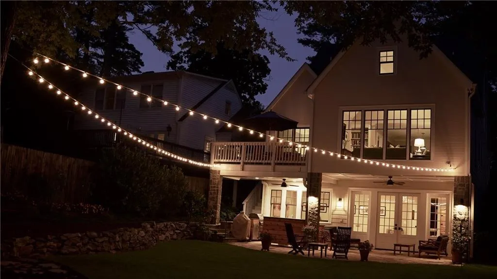 Back of house featuring french doors, a ceiling fan, a balcony, a yard, and a patio area