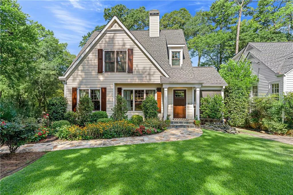 View of front of home featuring a shingled roof, a front lawn, and a chimney