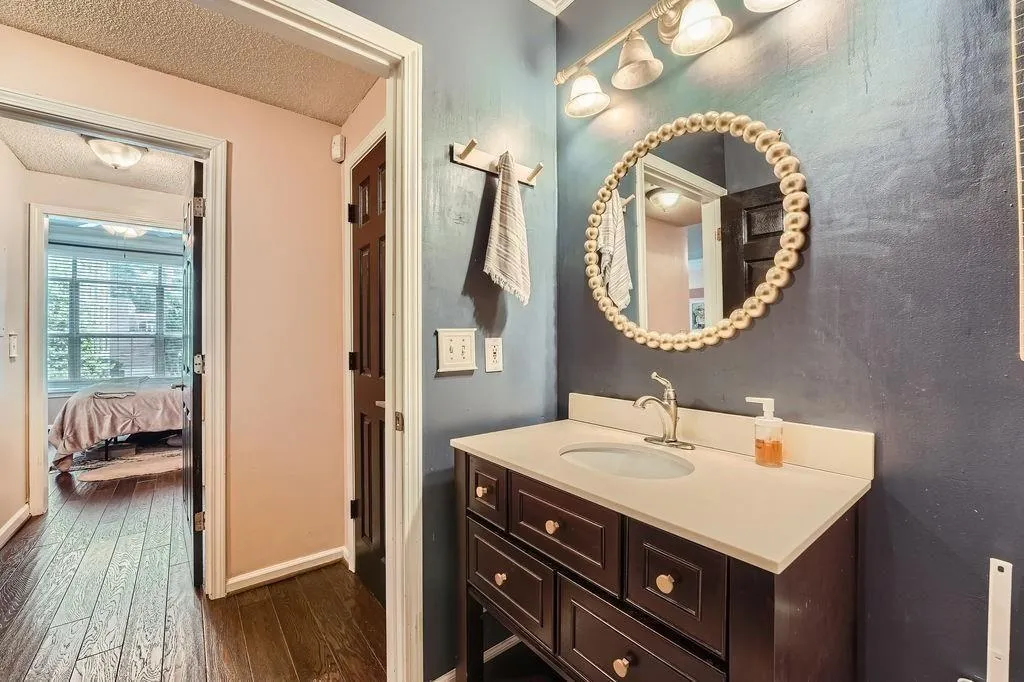 Bathroom featuring wood-type flooring, vanity, a textured ceiling, and connected bathroom