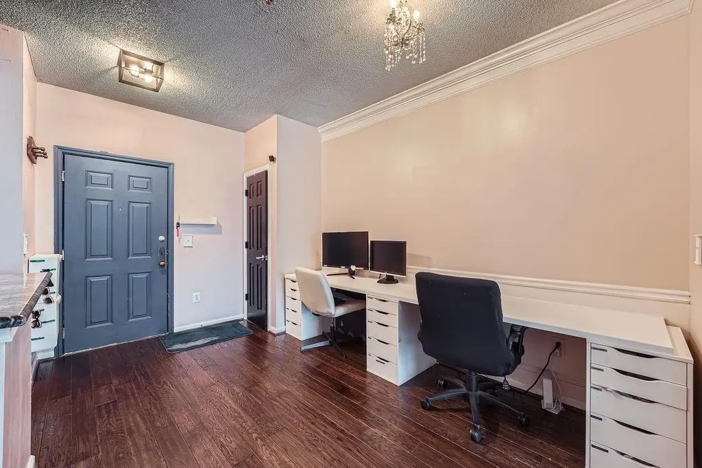 Office area with dark wood-style floors, a textured ceiling, and ornamental molding