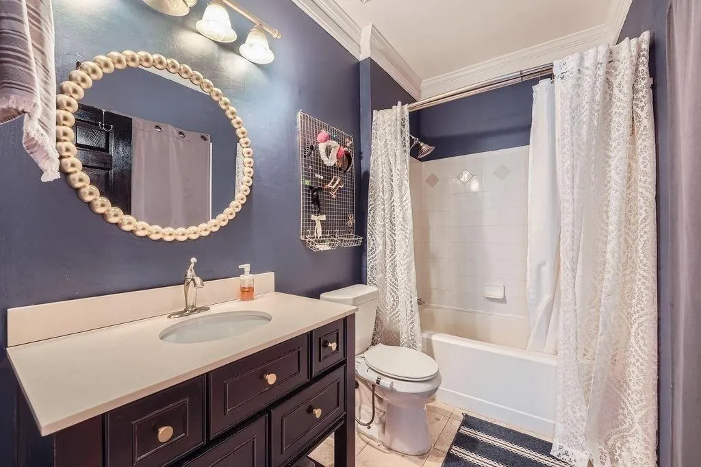 Full bathroom featuring crown molding, vanity, shower / bath combo, and tile patterned flooring