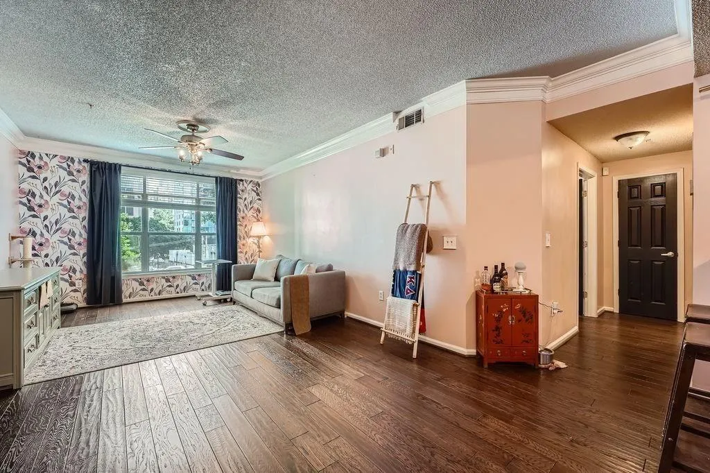 Sitting room with a textured ceiling, hardwood / wood-style flooring, ornamental molding, and a ceiling fan