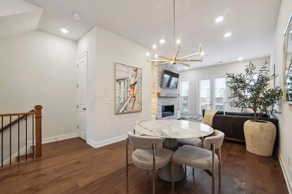 Dining space with a fireplace, dark wood-type flooring, lofted ceiling, and a notable chandelier