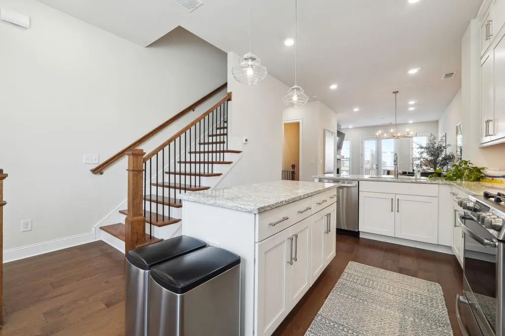 Kitchen featuring kitchen peninsula, stainless steel appliances, hanging light fixtures, and dark hardwood / wood-style floors