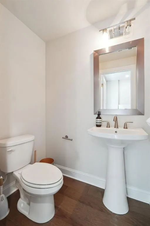 Bathroom featuring hardwood / wood-style flooring and toilet