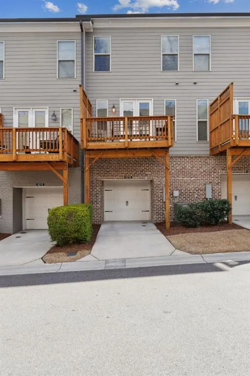 Back of house with a wooden deck, a garage, and central air condition unit