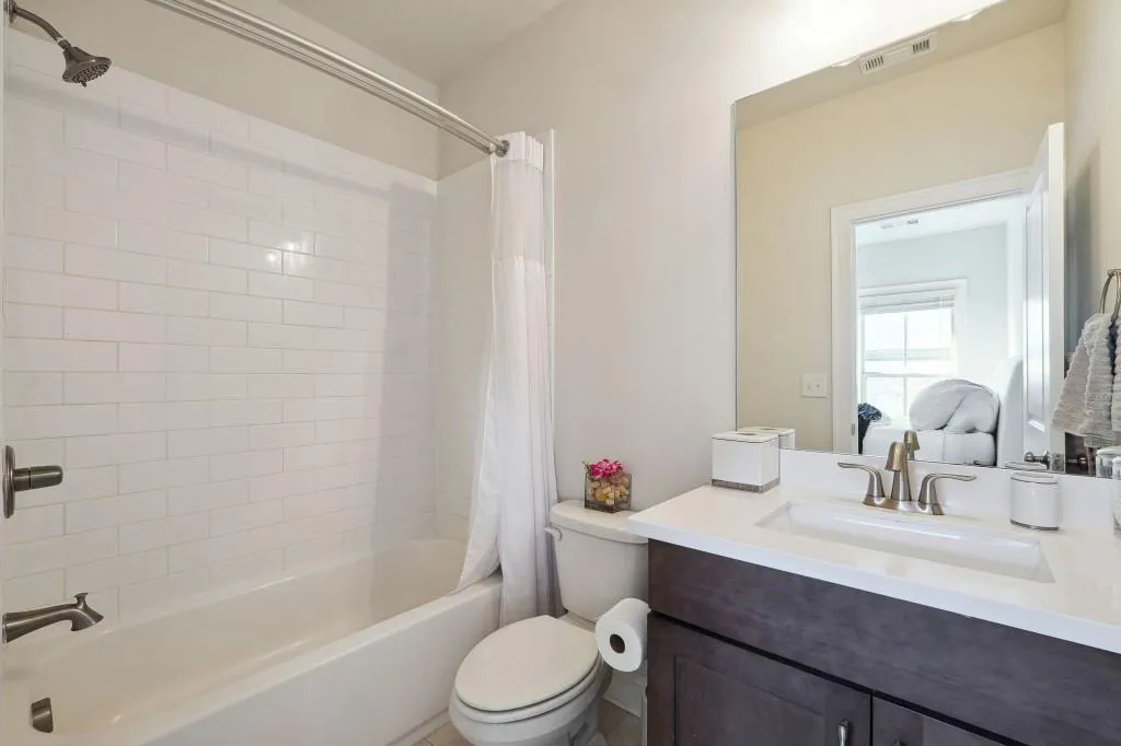 Full bathroom with shower / bathtub combination with curtain, toilet, and vanity