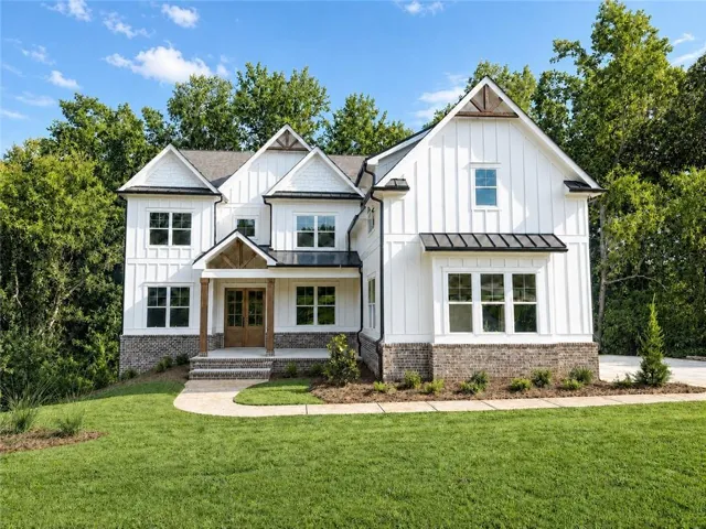 White board-and-batten siding with brick accents