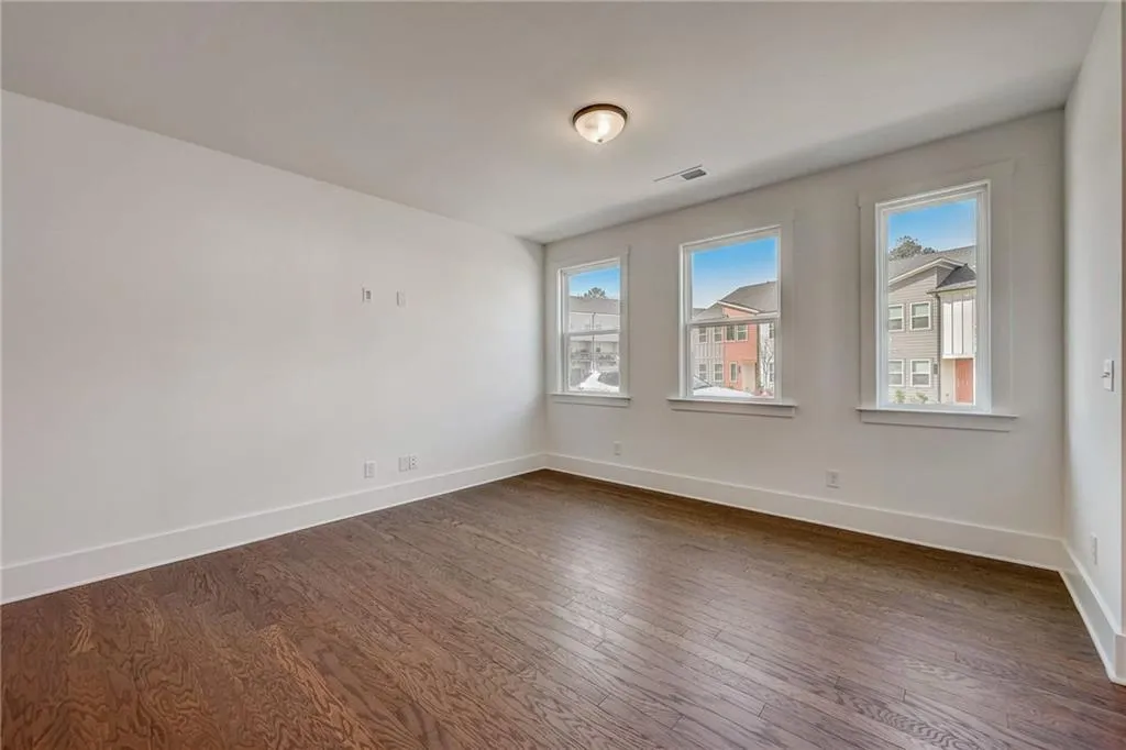 Empty room featuring dark wood-style floors and plenty of natural light