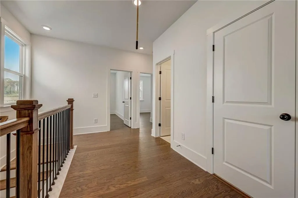 Hall featuring wood finished floors, an upstairs landing, and recessed lighting