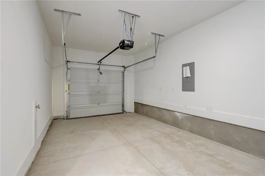 Garage featuring electric panel and a garage door opener