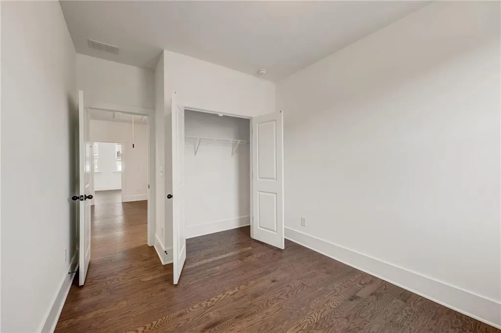 Unfurnished bedroom with dark wood finished floors and a closet