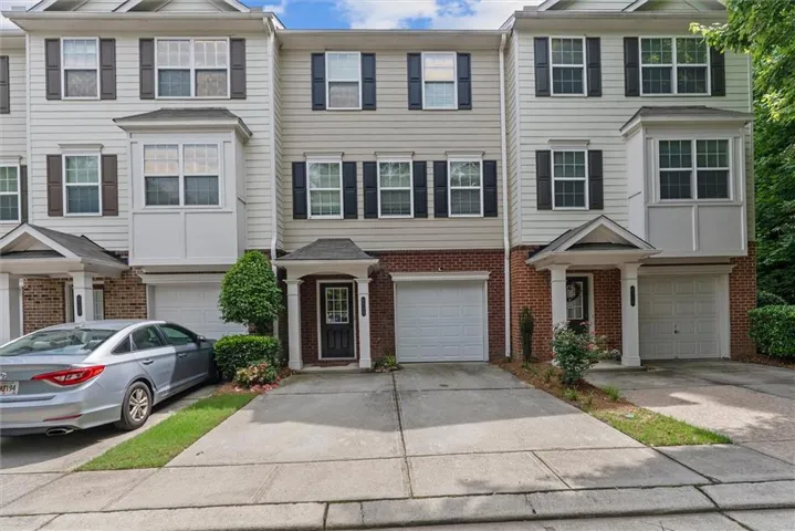 Brick and siding exterior with multiple bay windows, black shutters, and covered entryways