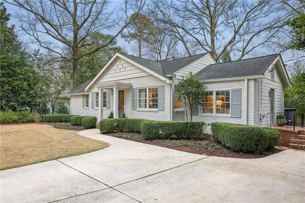 View of front of property with a front lawn, a shingled roof, and brick siding