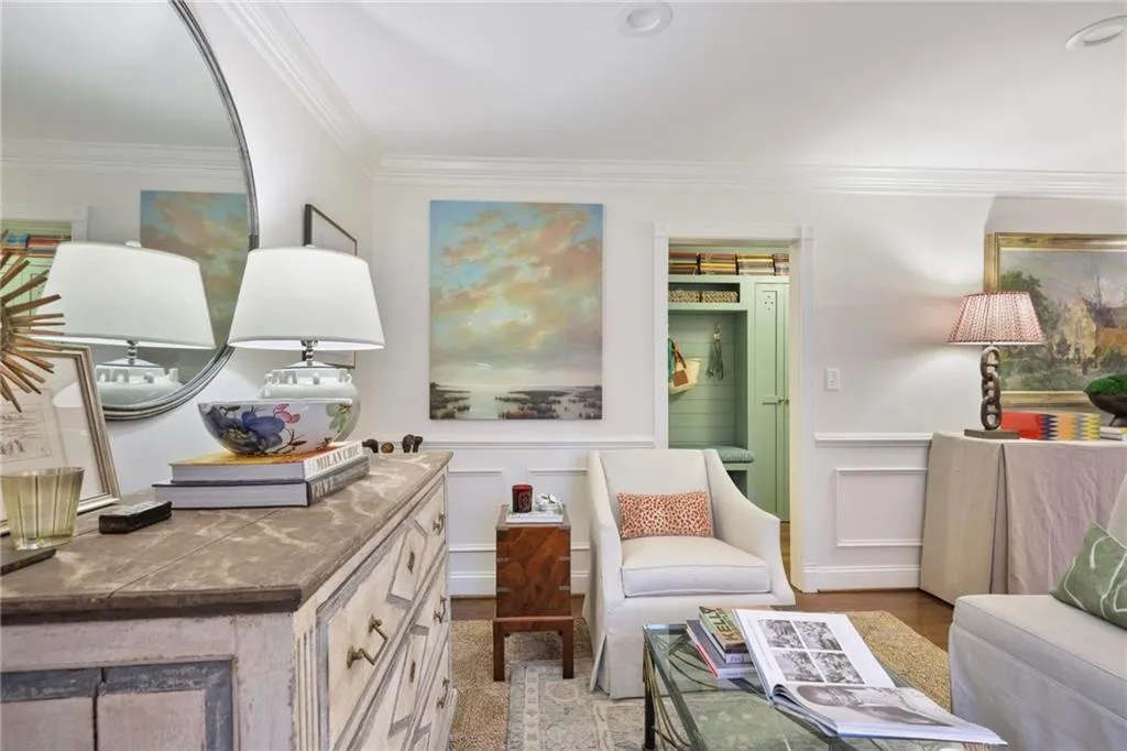 Living area with ornamental molding, wainscoting, a decorative wall, and wood finished floors