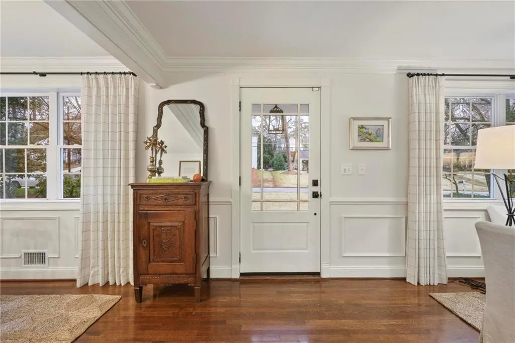 Foyer featuring ornamental molding, dark wood finished floors, visible vents, and a decorative wall