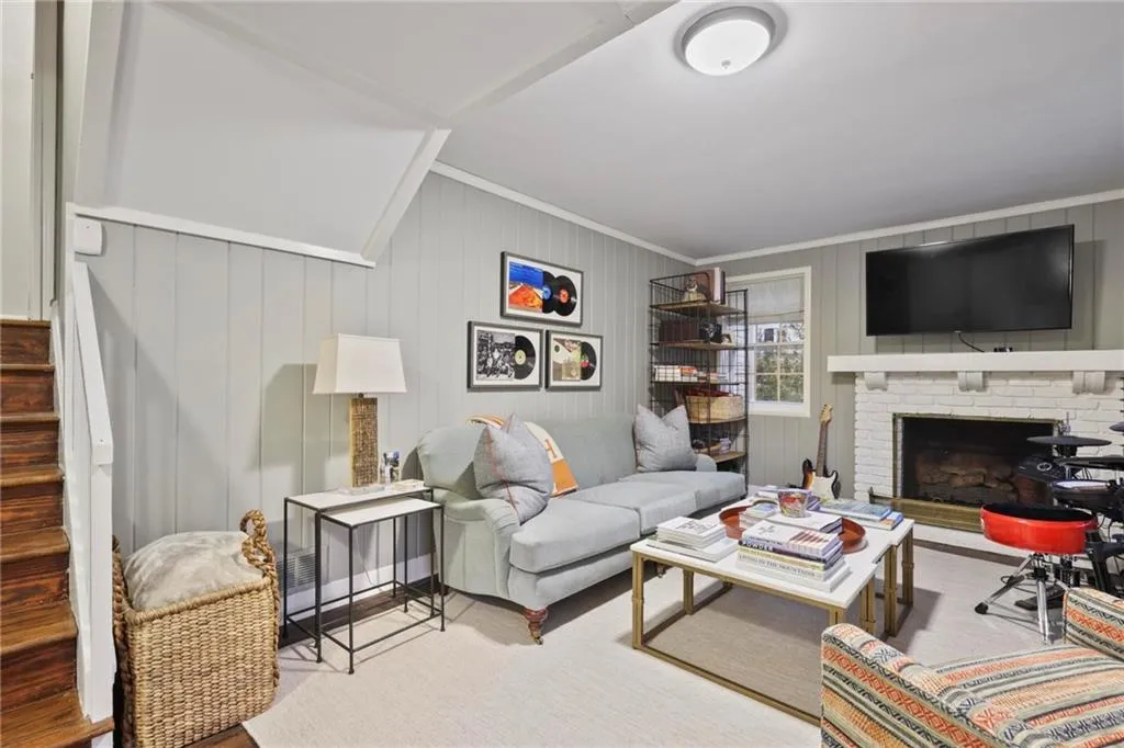 Carpeted living room featuring ornamental molding, a fireplace, and stairs