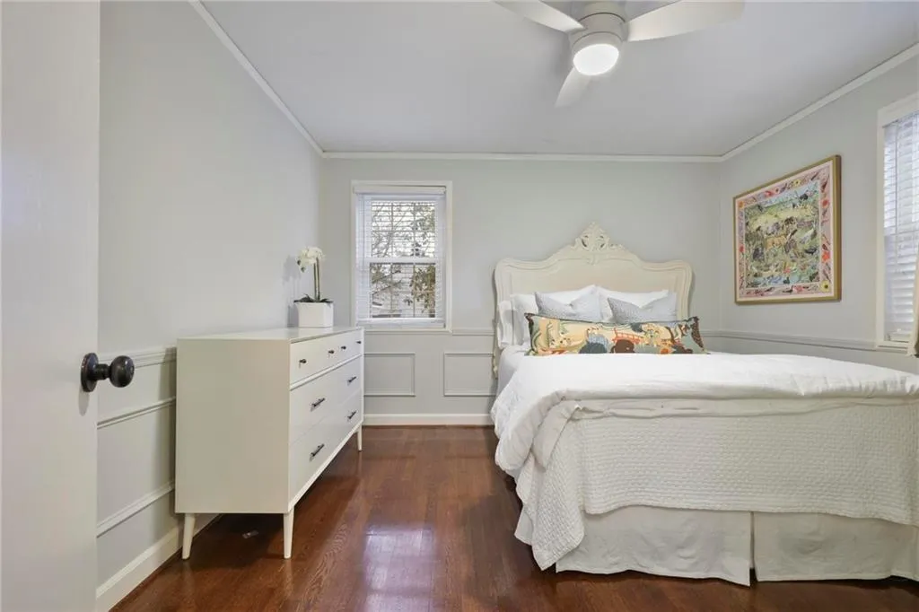 Bedroom featuring dark wood-style floors, a ceiling fan, and crown molding