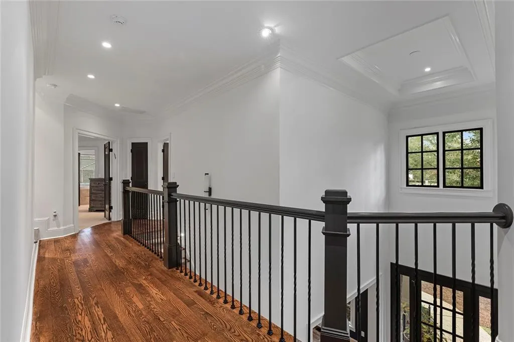Hallway featuring an upstairs landing, wood finished floors, recessed lighting, and ornamental molding