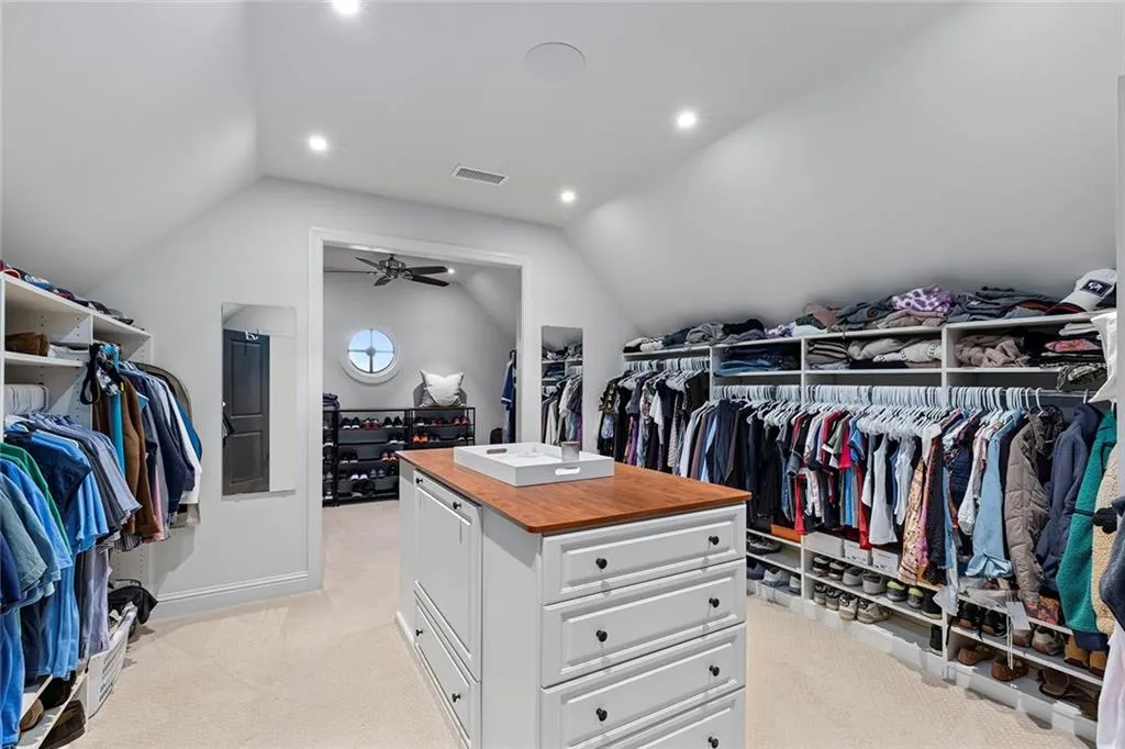 Spacious closet featuring light carpet and vaulted ceiling