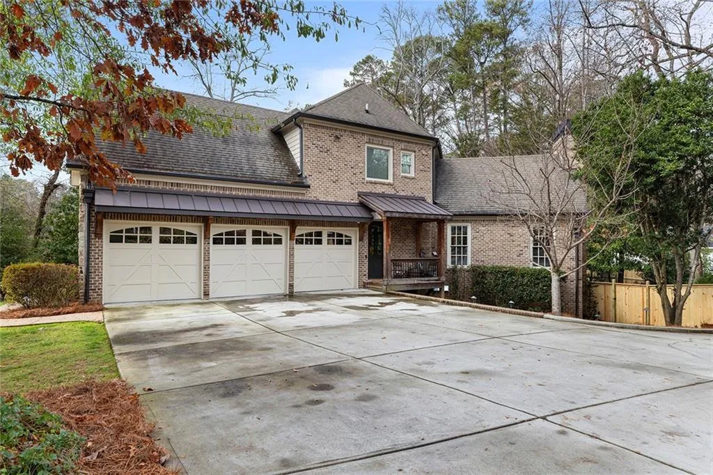 Traditional home featuring brick siding, driveway, roof with shingles, a porch, and an attached garage