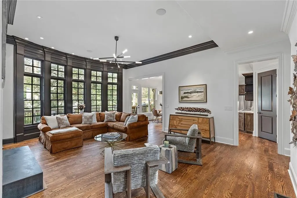 Living area with a chandelier, wood finished floors, crown molding, and recessed lighting
