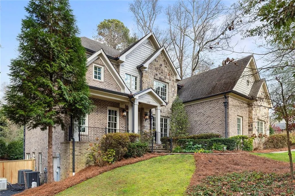 Craftsman-style home with covered porch, a front yard, a shingled roof, and brick siding