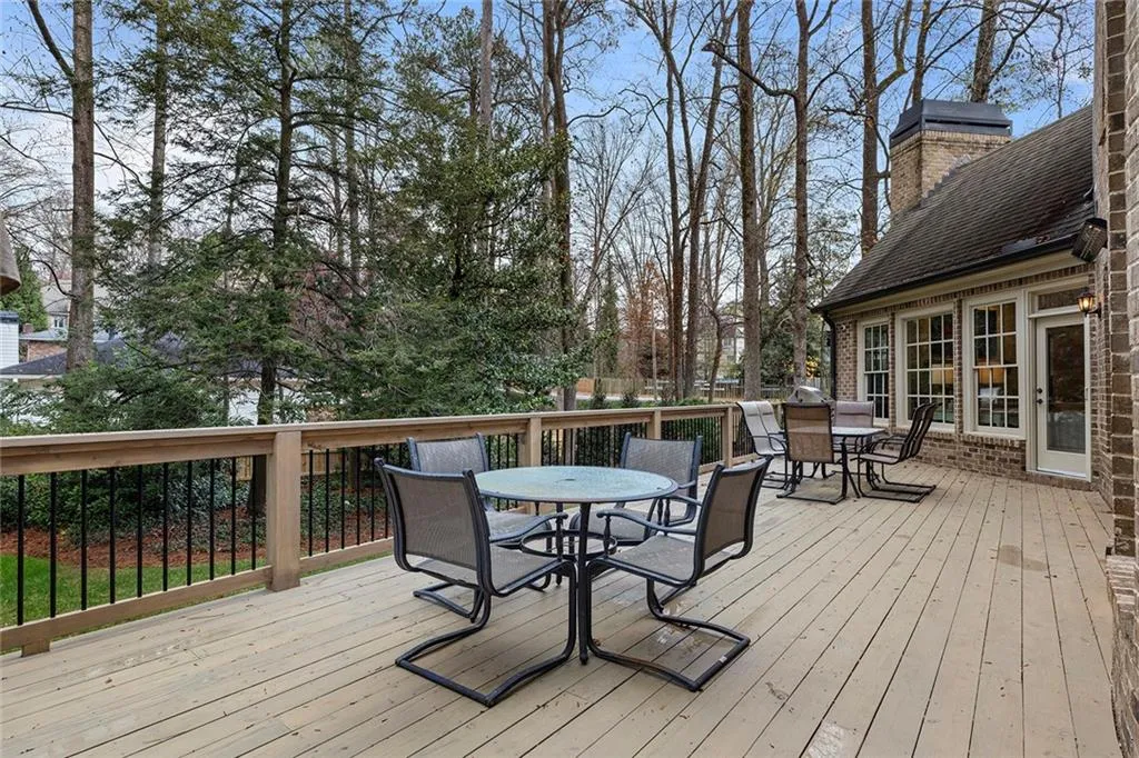 Deck with outdoor dining space and view of scattered trees