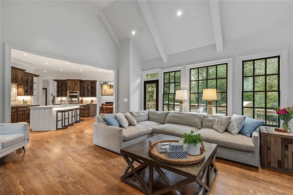 Living area with recessed lighting, high vaulted ceiling, beamed ceiling, and light wood-style flooring