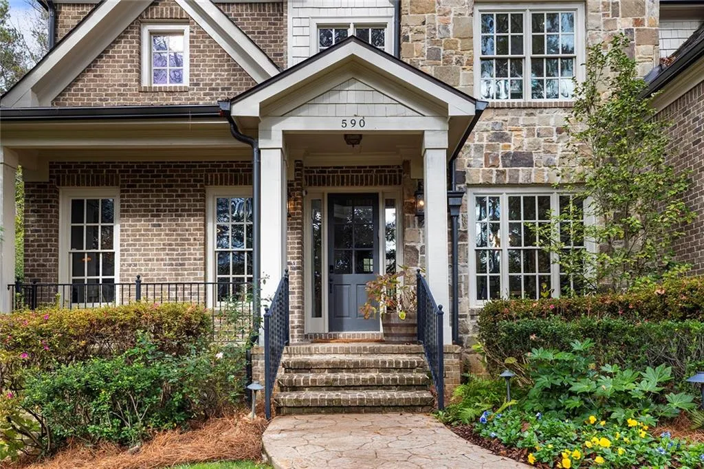 Doorway to property with brick siding and a porch