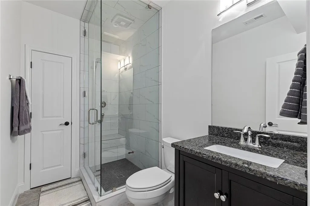 Bathroom featuring a shower stall and vanity