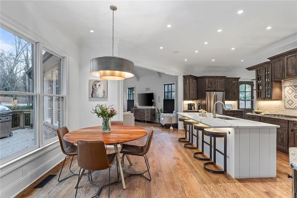 Dining room with crown molding, light wood-style flooring, and recessed lighting