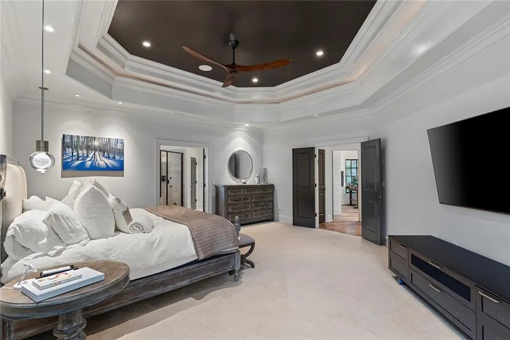 Bedroom featuring a ceiling fan, crown molding, a tray ceiling, light colored carpet, and recessed lighting