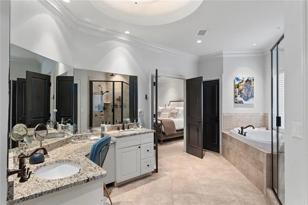 Full bathroom with crown molding, a stall shower, double vanity, light tile patterned floors, and a garden tub