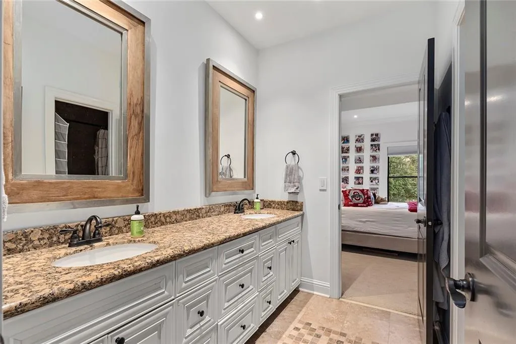 Ensuite bathroom with double vanity, recessed lighting, and light tile patterned floors