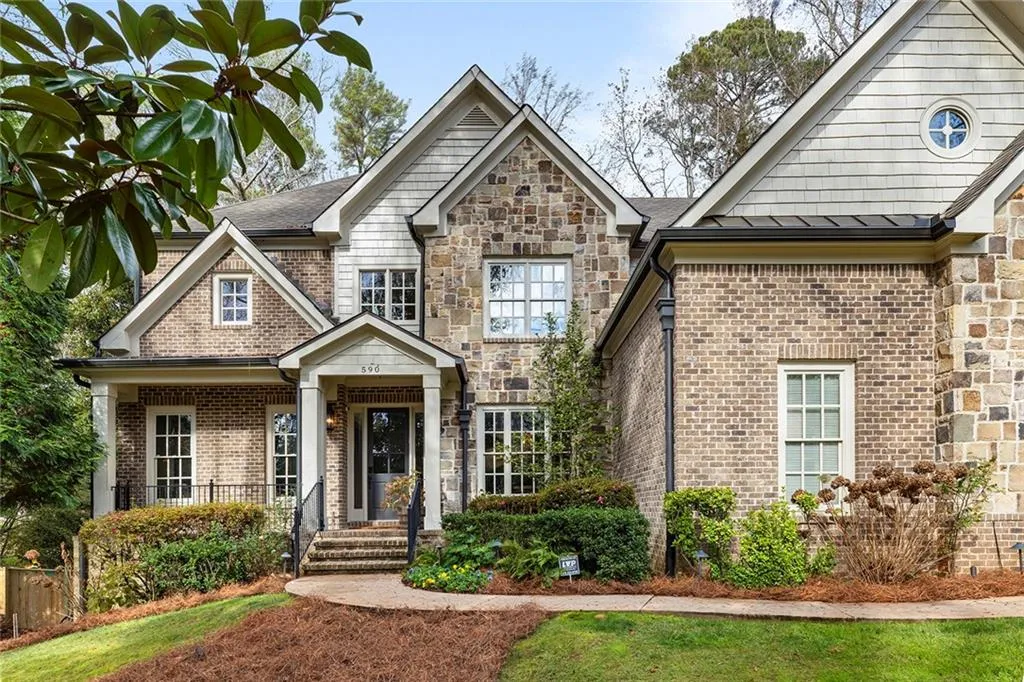 Craftsman-style house with brick siding, a porch, and a standing seam roof