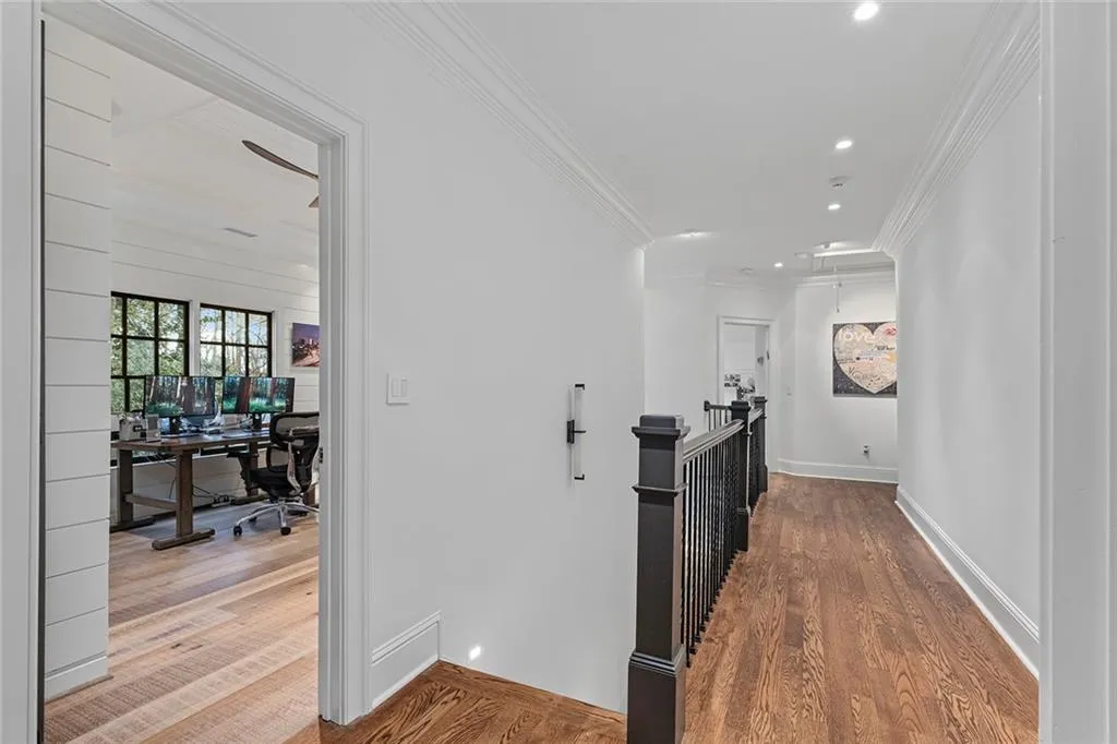 Corridor with an upstairs landing, an office area, wood finished floors, crown molding, and recessed lighting