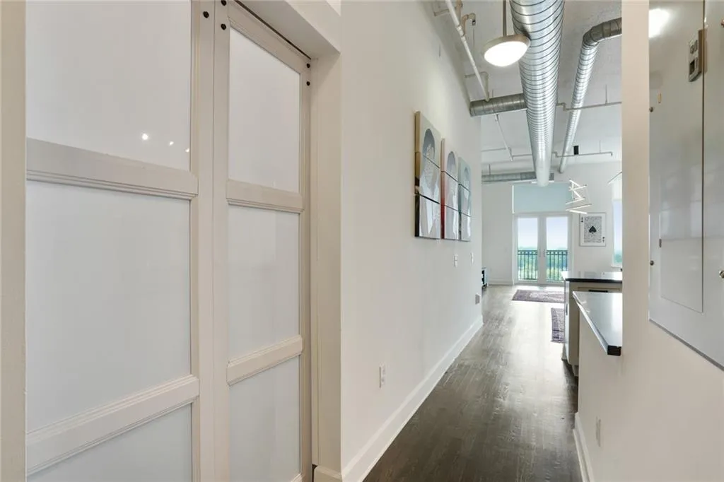 Hall featuring baseboards and dark wood-style flooring