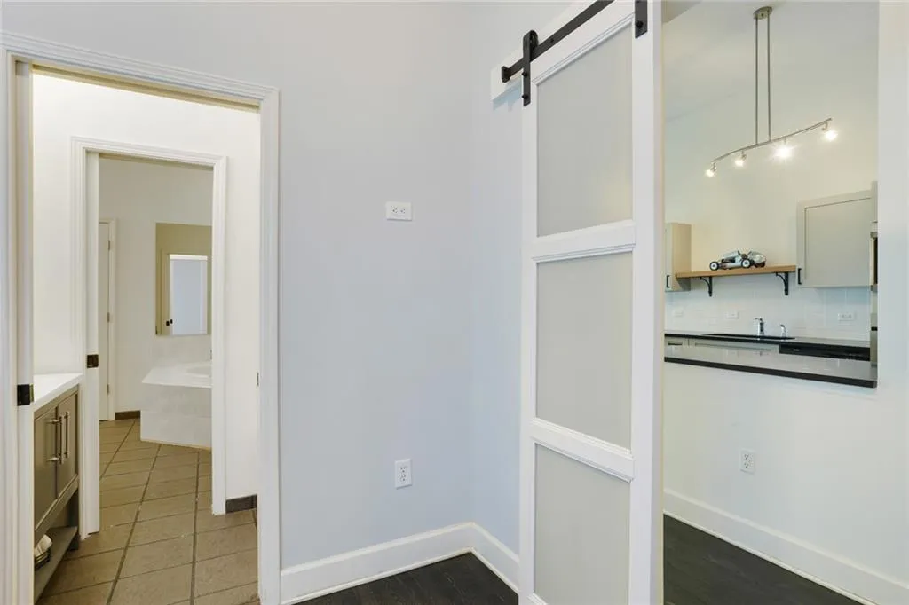 Hall featuring a barn door and dark tile patterned flooring